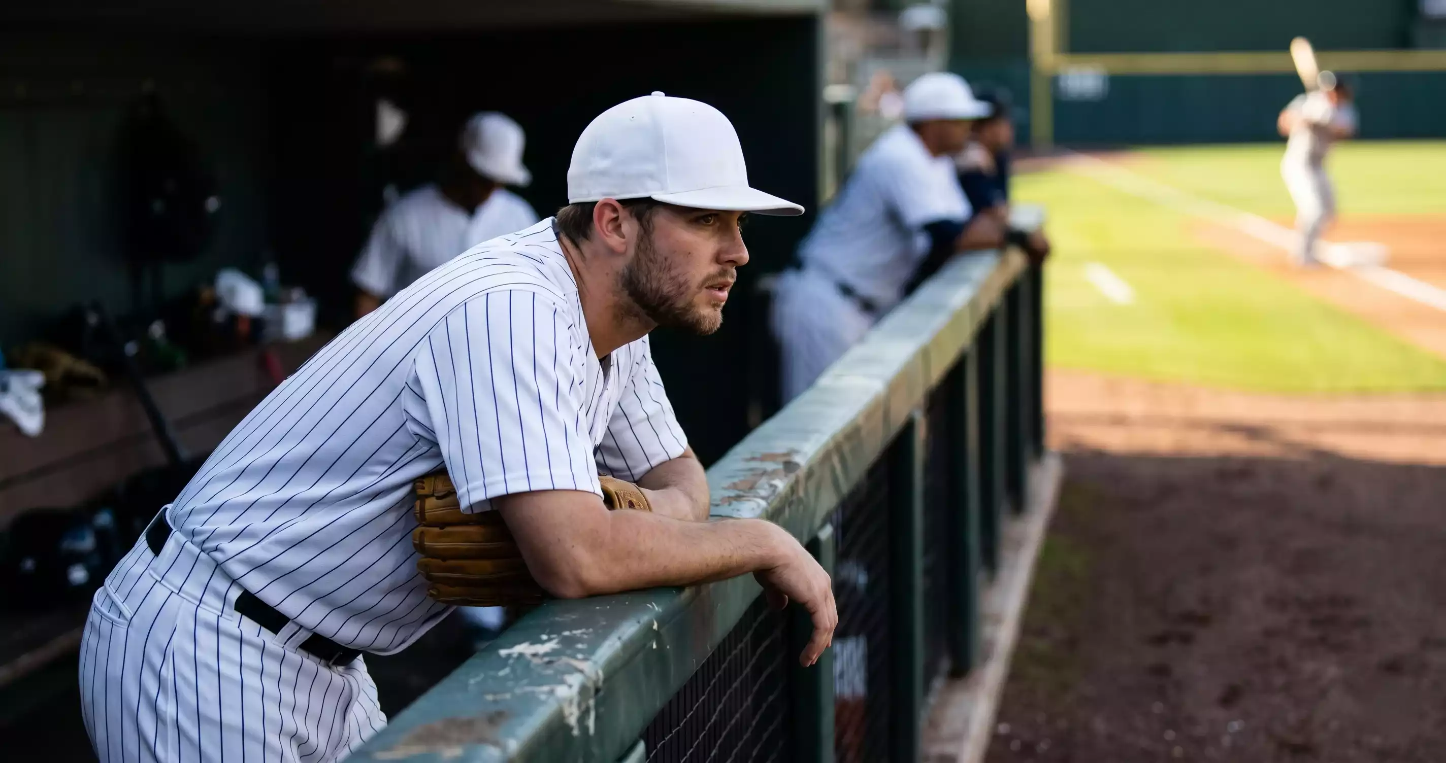 MLB home team bullpen reliever watching the field from the dugout